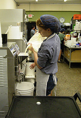 Shannon Leach pours ice cream mix into an ice cream maker at Izzy's Ice Cream Cafe