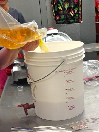 Pouring the bagged juice concentrate into the primary fermenter bucket.